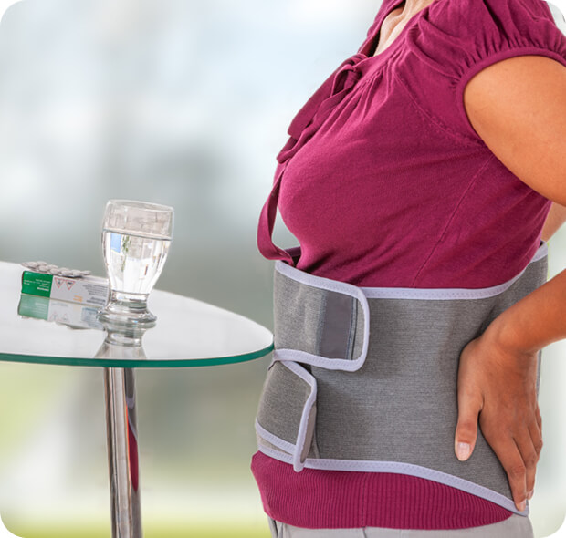 na sliki je trup ženske, ki ima okoli hrbta in trebuha pas, ki preprečuje oziroma pomaga za bolečine v hrbtu